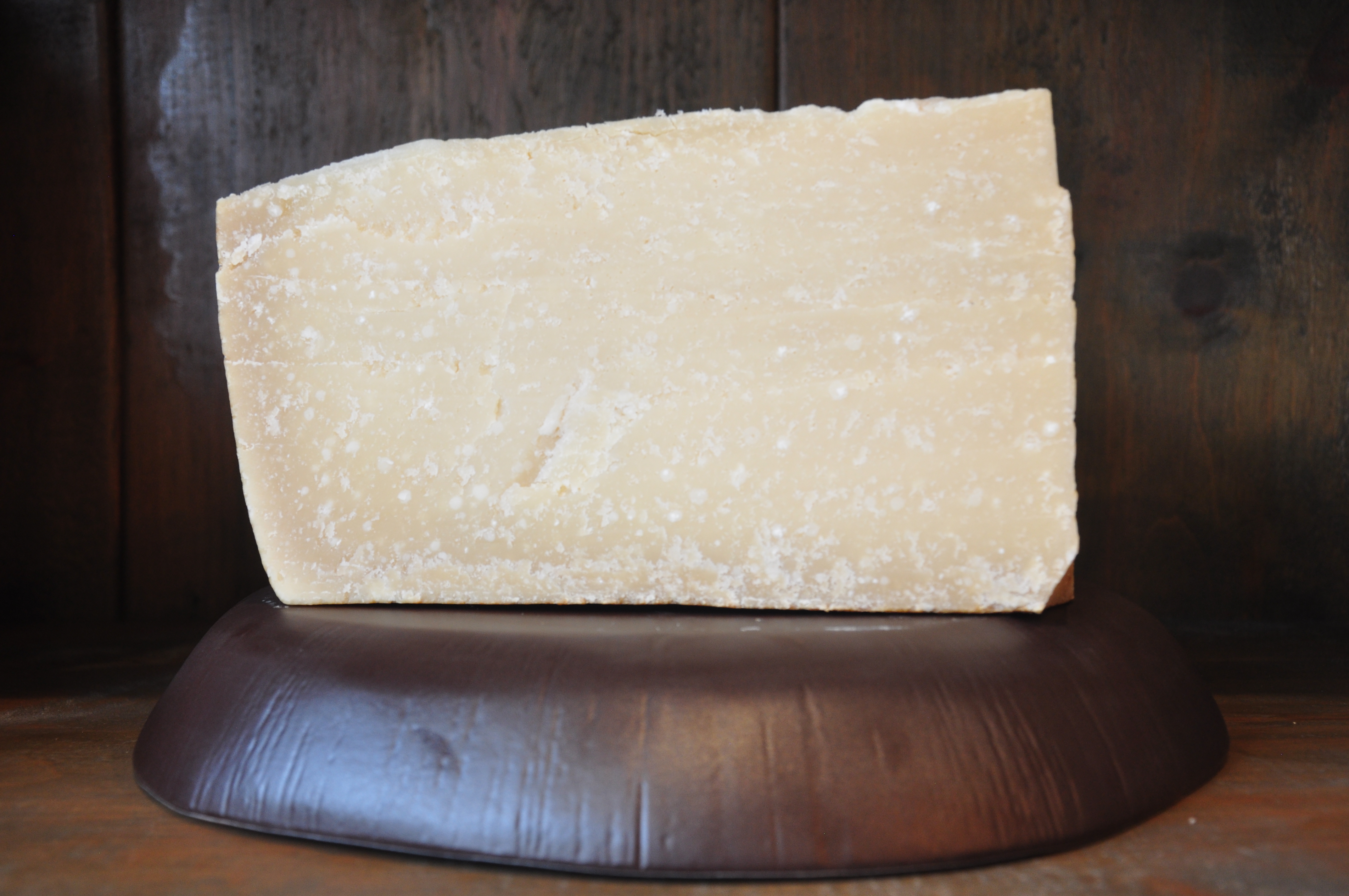Large wedge of Parmigiano Reggiano showing grainy aged texture